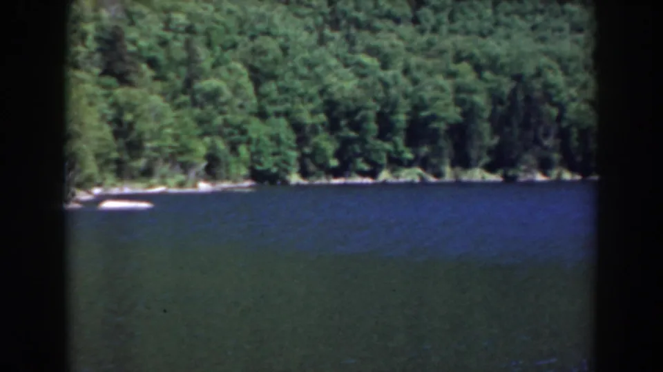 Steady 8mm view of a blue lake and wooded New Hampshire shoreline, likely near Mount Washington based on clip metadata.