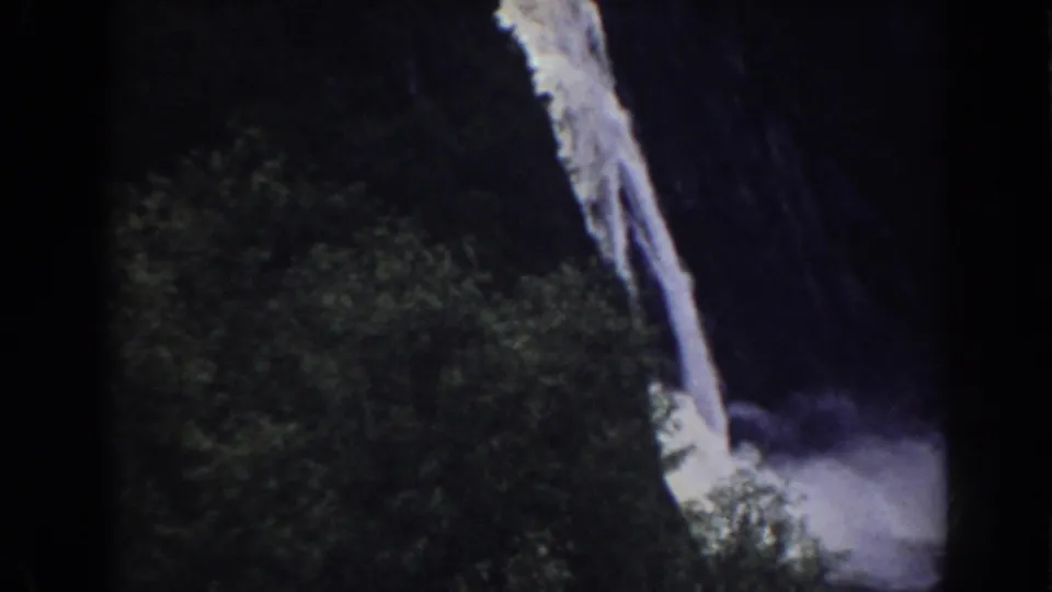 Mount Washington area 8mm frame showing the waterfall continuing toward a misty base, partly obscured by trees and shadow.