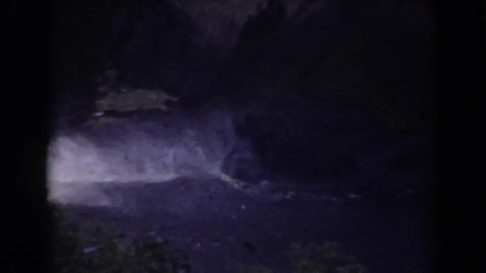 1938 Mount Washington footage appears to show dim rapids or river water running beside rocky, shadowed mountain ground.