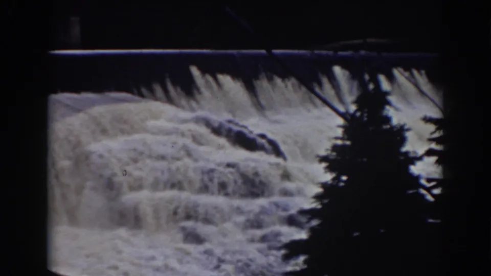 1938 8mm Mount Washington footage showing white water over a ledge, dark rocks, and a silhouetted pine in the foreground.