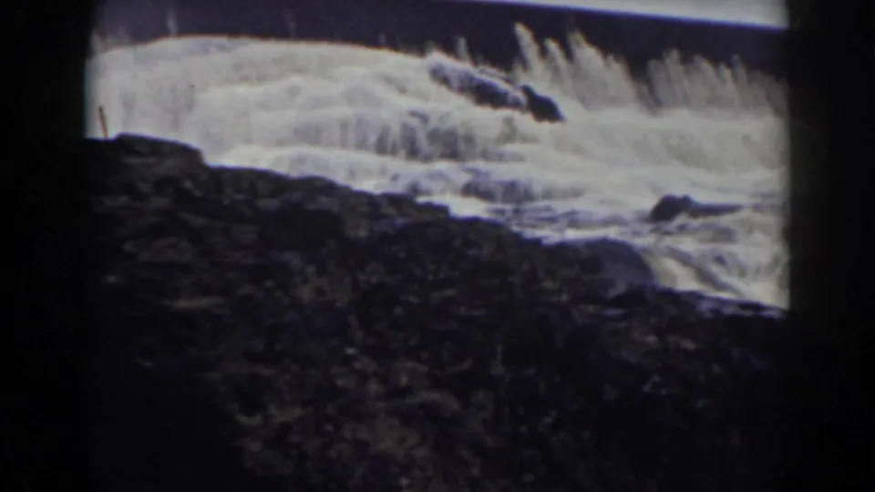 1938 Mount Washington waterfall view with rushing water over a ledge and a dark rock face filling the lower frame.