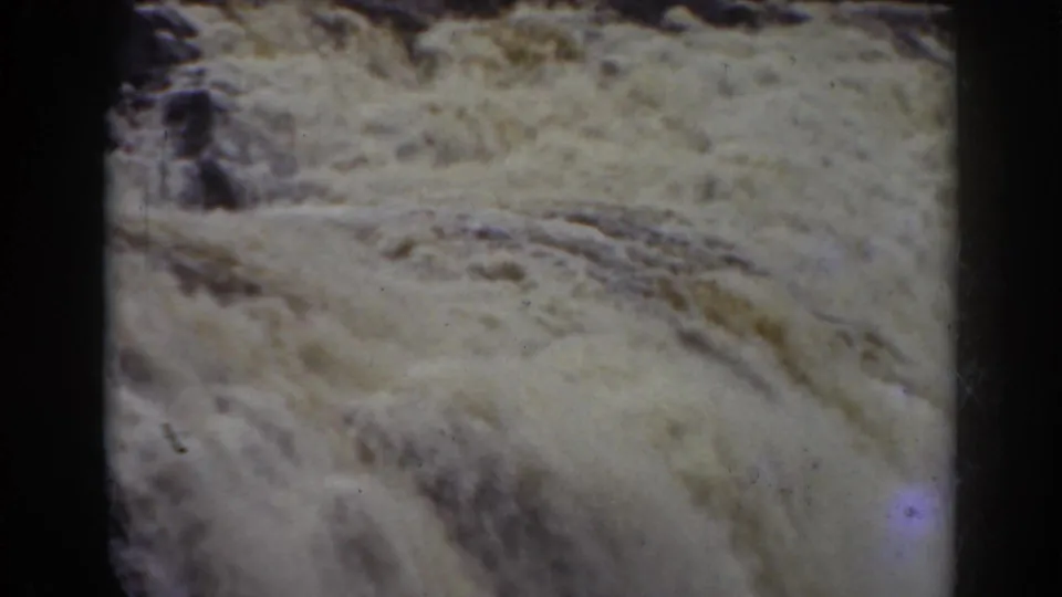Close 1938 8mm frame of turbulent falls water at Mount Washington, with rocks partly visible through foam.