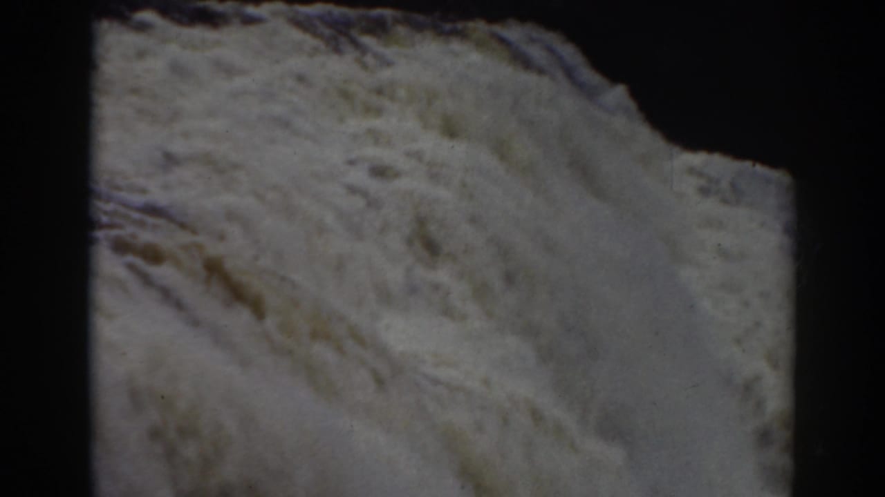 Close 1938 8mm view of turbulent white water at Crystal Cascade near Mount Washington, with dark frame edges and soft grain.