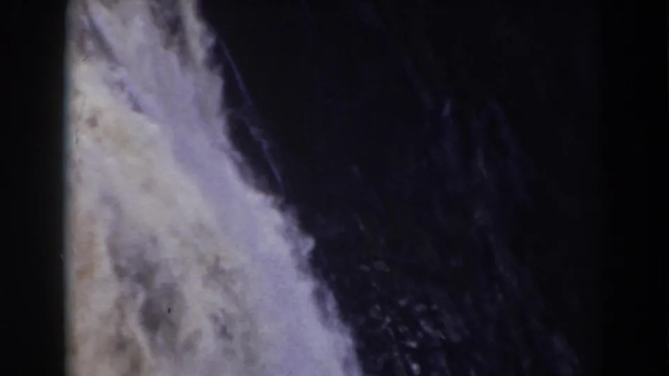 Close view of Crystal Cascade water against a shadowed rock face, with visible 8mm grain, soft focus, and faded color from the 1938 footage.