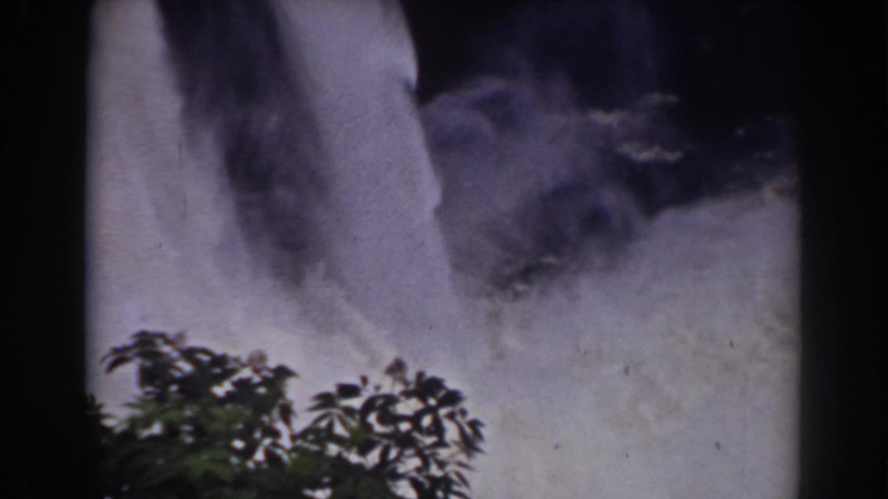 1938 home-movie view near Mount Washington showing the waterfall base, mist, and foreground leaves.