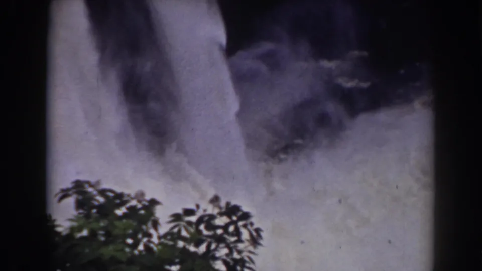 1938 home-movie view near Mount Washington showing the waterfall base, mist, and foreground leaves.