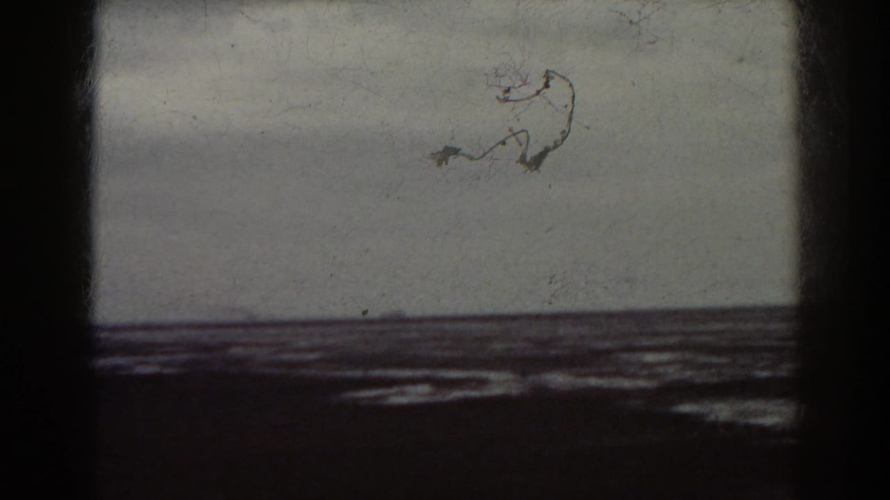 1938 8mm frame tied to the Mount Washington, New Hampshire metadata, showing distant water and shoreline with visible film wear.