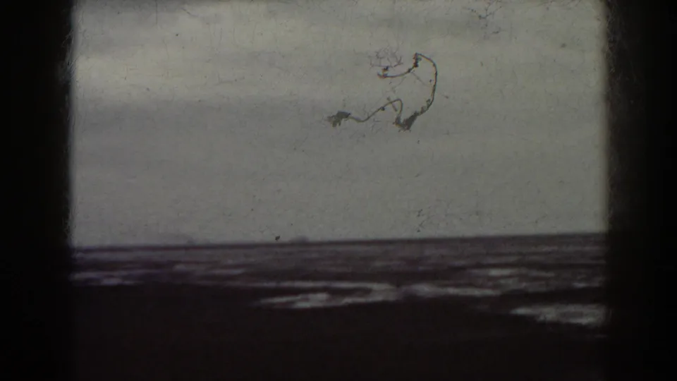 1938 8mm frame tied to the Mount Washington, New Hampshire metadata, showing distant water and shoreline with visible film wear.