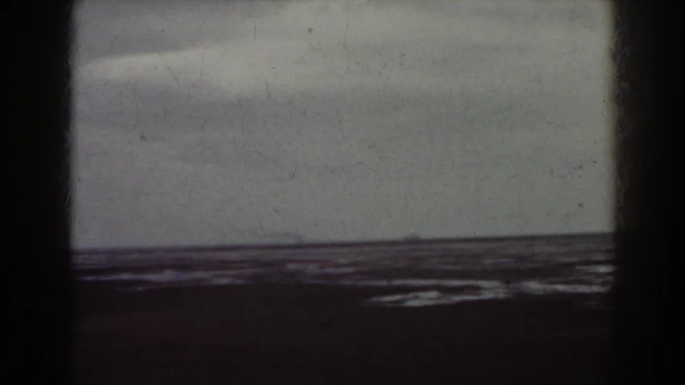 A 1938 home-movie view associated with Mount Washington, New Hampshire, with a still shoreline, low waterline, and visible 8mm texture.