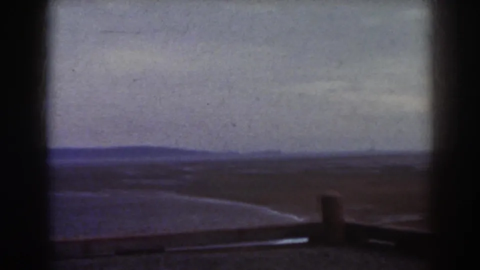 Framed 1938 Mount Washington view with a broad plain, low foreground barrier, small post, and blue-toned distant hills.