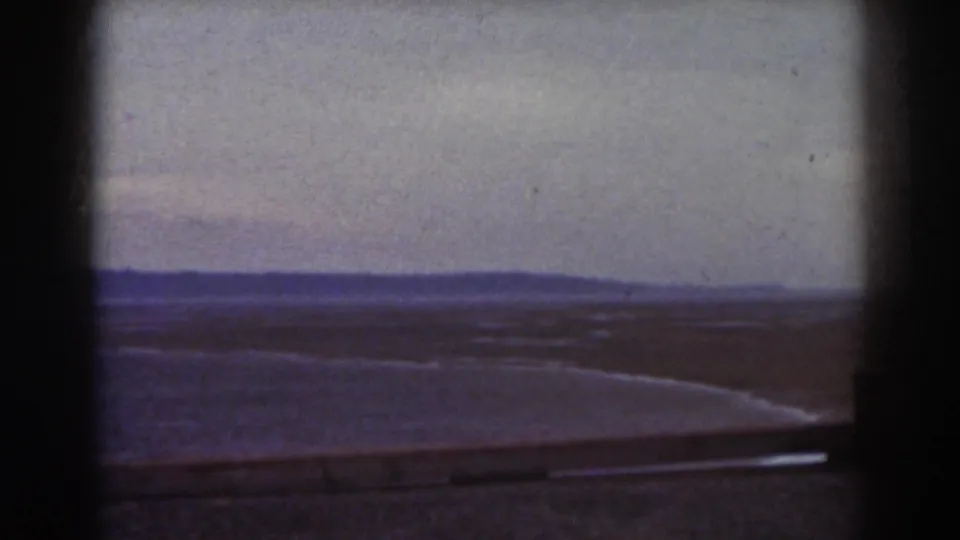 1938 Mount Washington landscape frame with open ground, a low barrier, distant hills, and faded 8mm color.