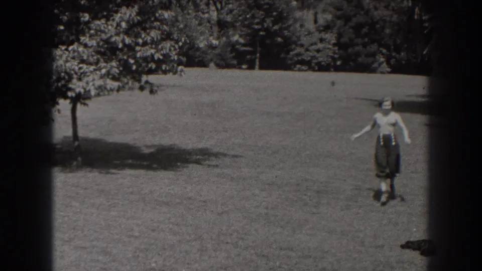 A woman appears near the right side of the 1938 New Jersey park scene, with lawn and trees behind her.