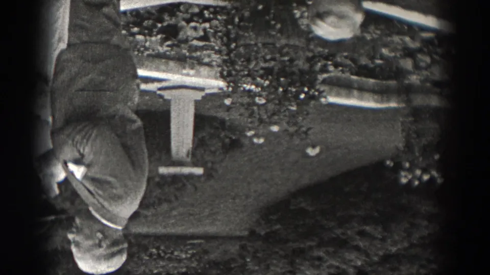 Inverted 1938 New Jersey home-movie frame showing an older man near a small fountain and planted outdoor area.