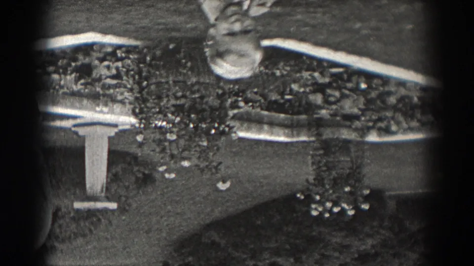 Inverted 1938 New Jersey home-movie frame showing a man and partial second figure beside a small outdoor fountain.