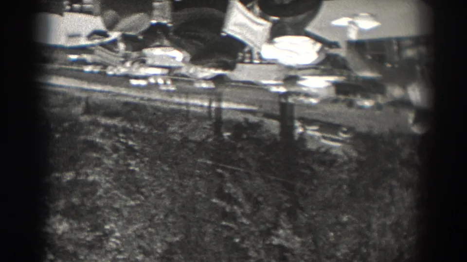 1938 New Jersey home-movie frame showing an elevated city view with rooftops, trees, utility poles, and lamps.