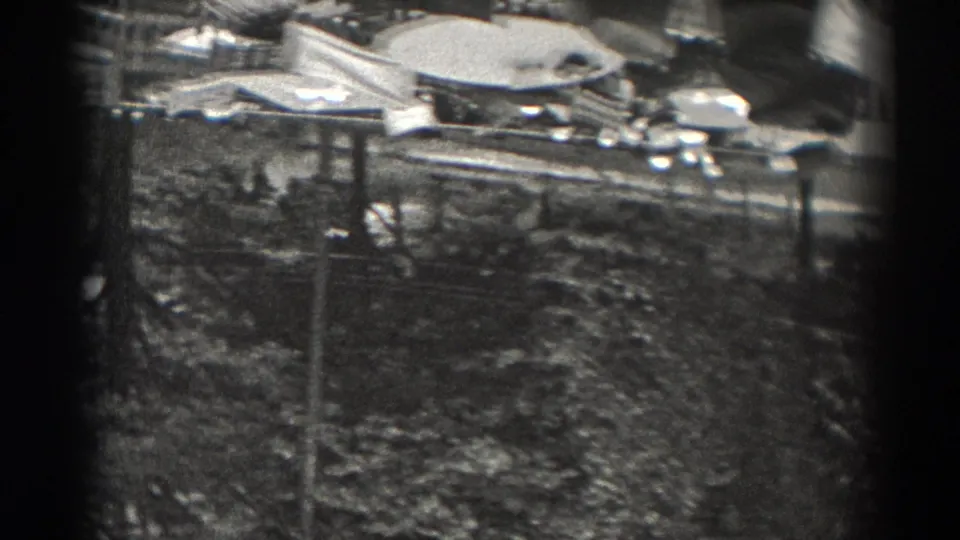 High-angle 1938 New Jersey view across a tree-lined city area with rooftops, poles, and light-colored ground surfaces.