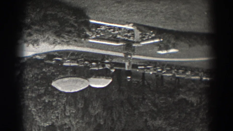 Black-and-white 8mm view of 1938 New Jersey garden seating, with umbrellas, tables, lawn, and trees.