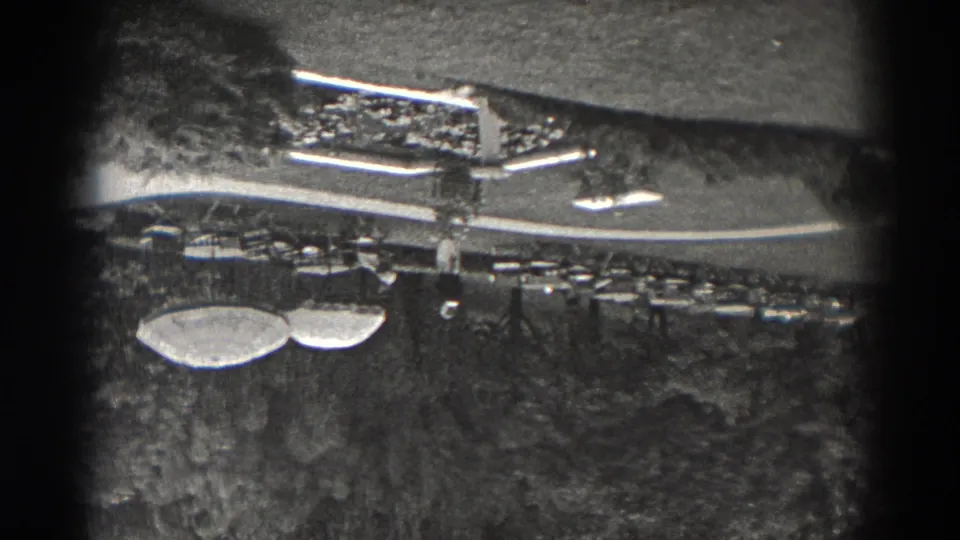 1938 New Jersey 8mm frame showing an upside-down elevated view of lawns, trees, curving paths, and a long low park structure.