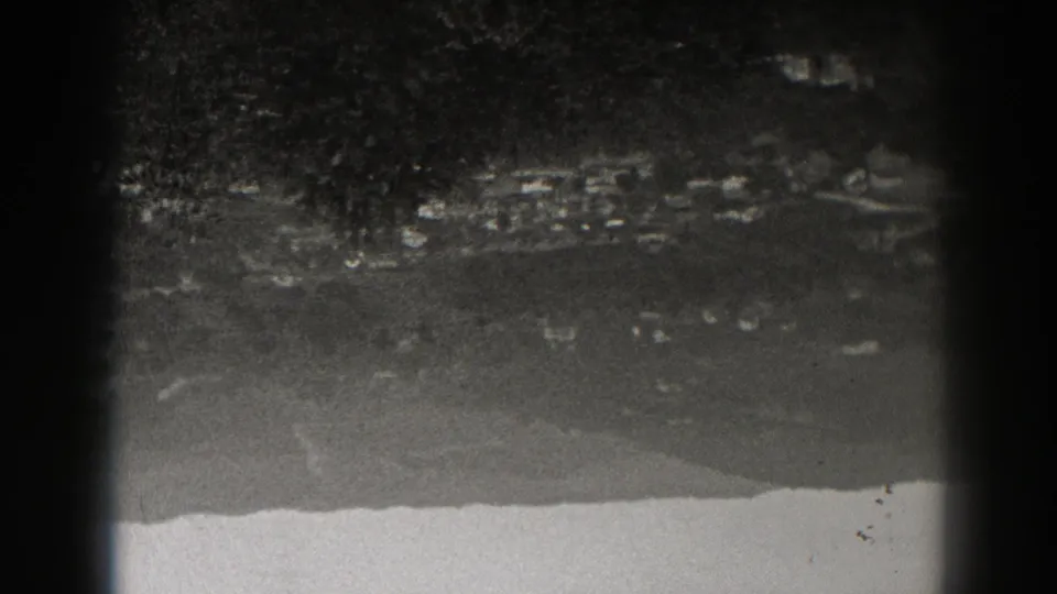 1938 New Jersey 8mm night frame with a blurred distant horizon, faint light marks, and a pale strip at the bottom.