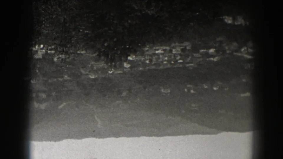 Late-1930s New Jersey 8mm frame showing distant clustered lights in a dark, soft, heavily grained night landscape.