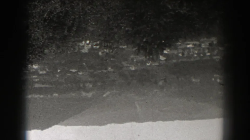 Grainy 1938 New Jersey 8mm still showing an upside-down elevated look at roads, trees, hillside clearings, and distant houses.