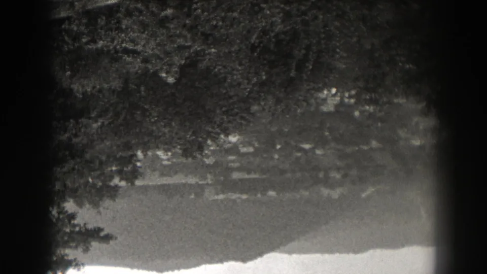 Black-and-white New Jersey lake reflection from 1938, with trees, a faint slope, rippled water, and dark 8mm frame edges.