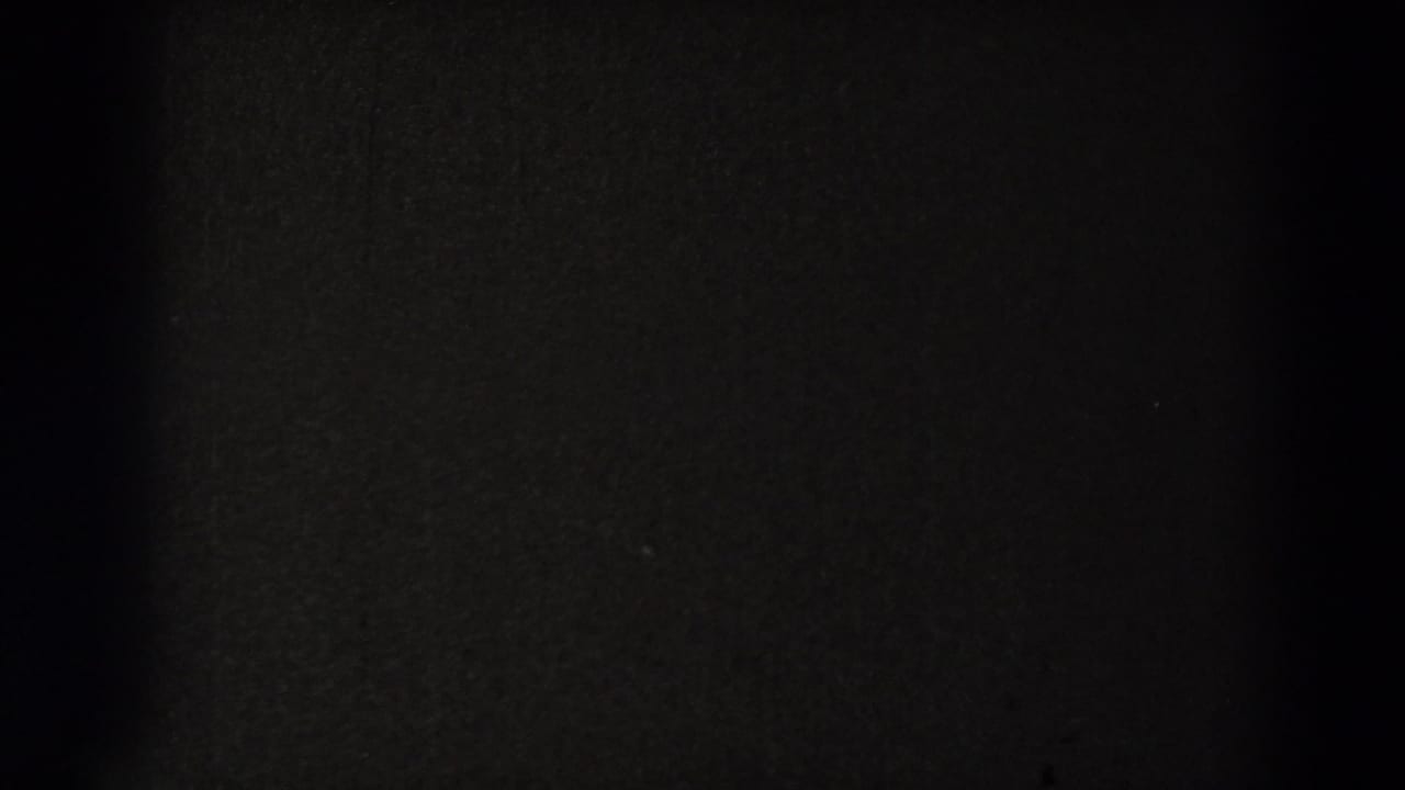 Nearly black 8mm frame with subtle film texture, likely part of an end-roll or transition section.