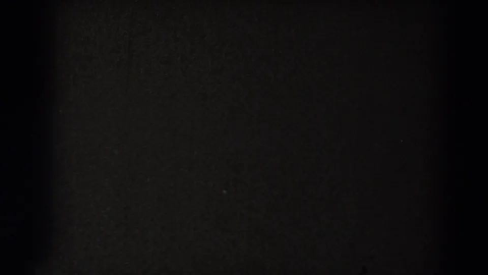 Nearly black 8mm frame with subtle film texture, likely part of an end-roll or transition section.