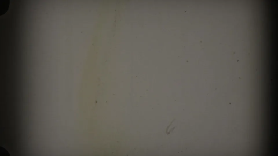 Blank pale 8mm frame with dust marks, scratches, grain, and dark gate-edge shadowing.