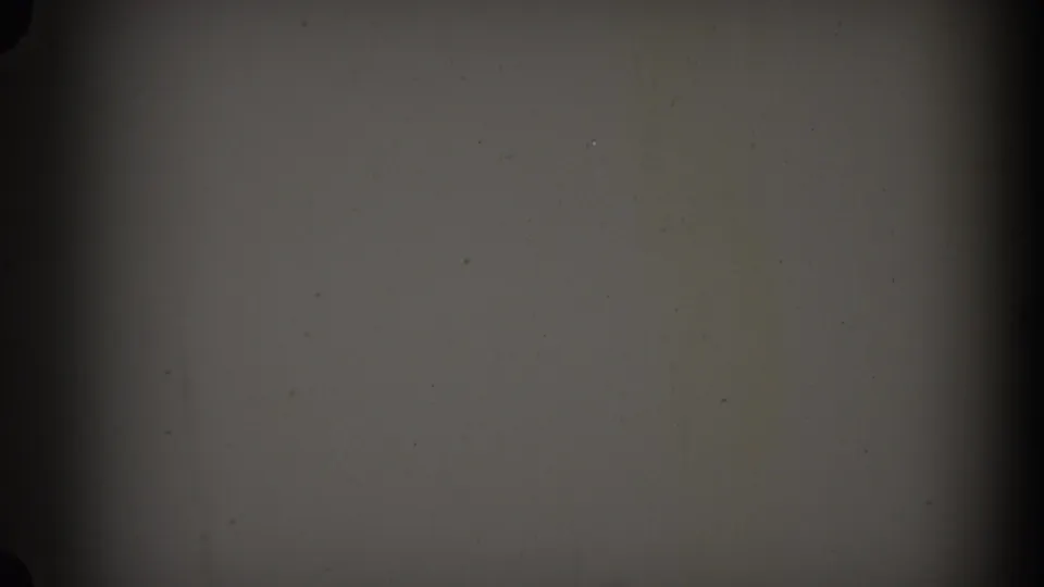 Blank gray 8mm frame with dark edge shading, grain, and scattered dust marks at the end of the clip.