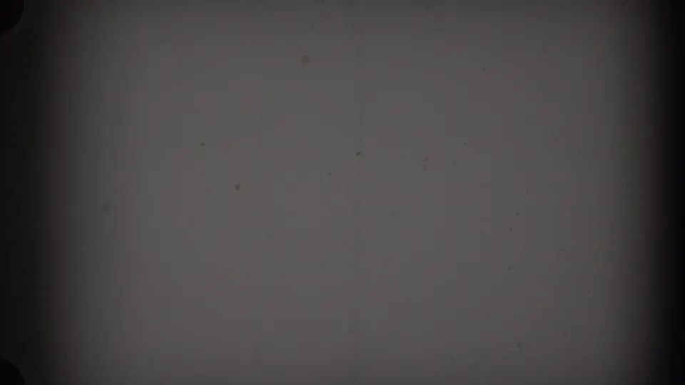 1938 New Jersey 8mm frame showing mostly dark black-and-white film surface, dust specks, scratches, and a heavy vertical shadow band.