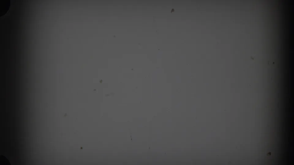 1938 New Jersey home-movie frame with a nearly blank gray field, scattered dust marks, and darkened film edges.