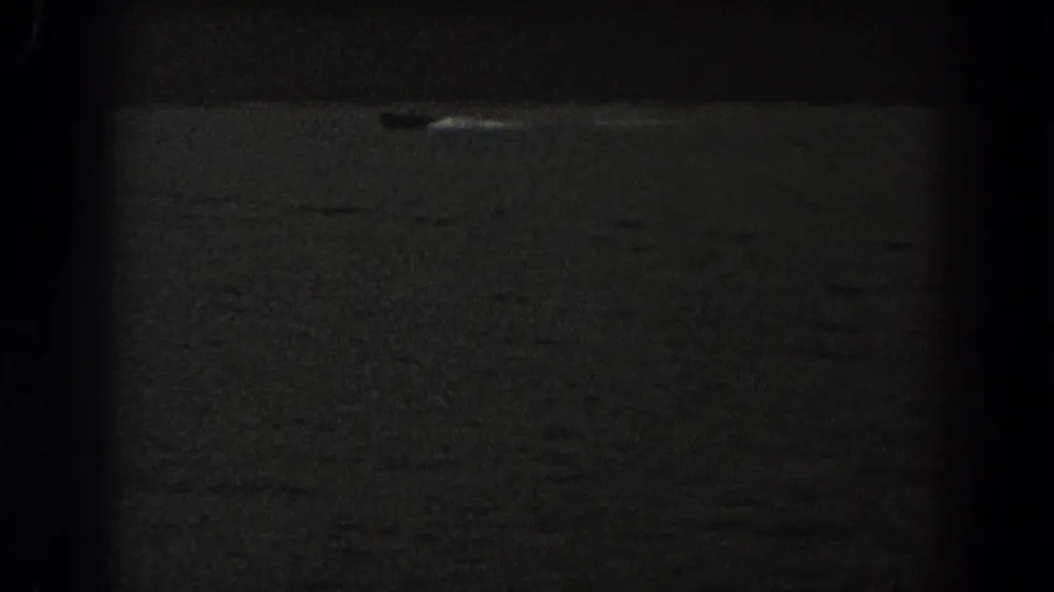 1938 New Jersey 8mm frame showing a distant small boat moving across dark rippling water.