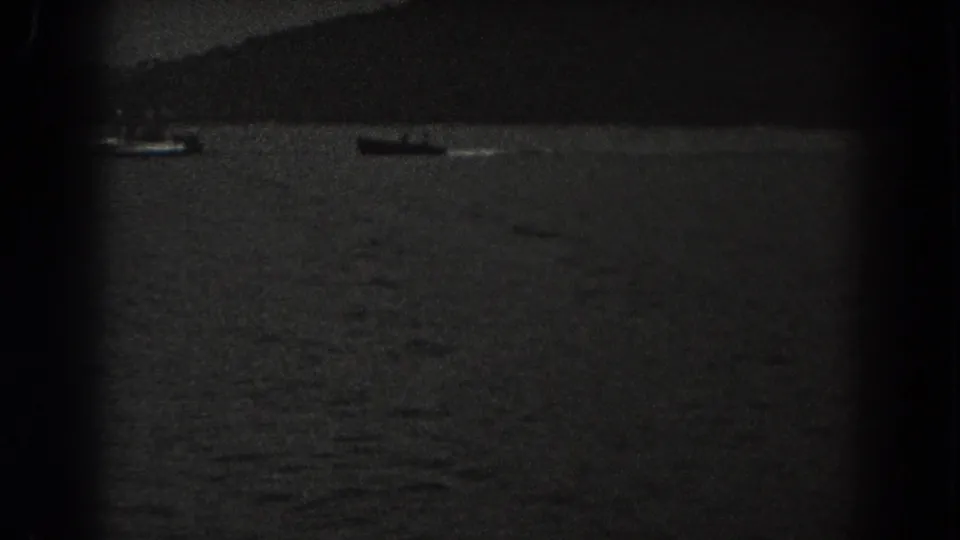 1938 New Jersey lake frame with a small boat near a shadowed shoreline and indistinct forest edge.