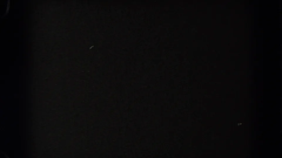 The final frame is almost entirely black, with faint specks and film-border texture from the 8mm scan.