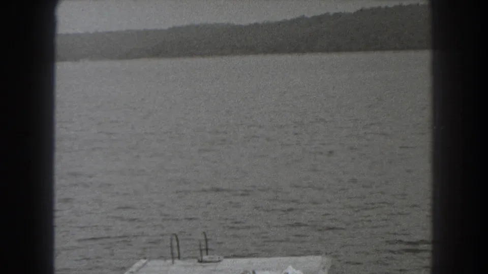 1938 New Jersey lake view with wooded shore in the distance and part of a dock entering the lower frame.