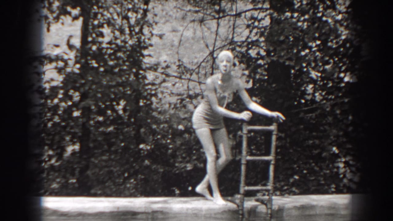 Swimmer holding a metal ladder at the edge of an outdoor pool.