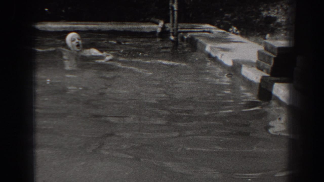 Woman in a swim cap swims near the edge of a backyard pool.