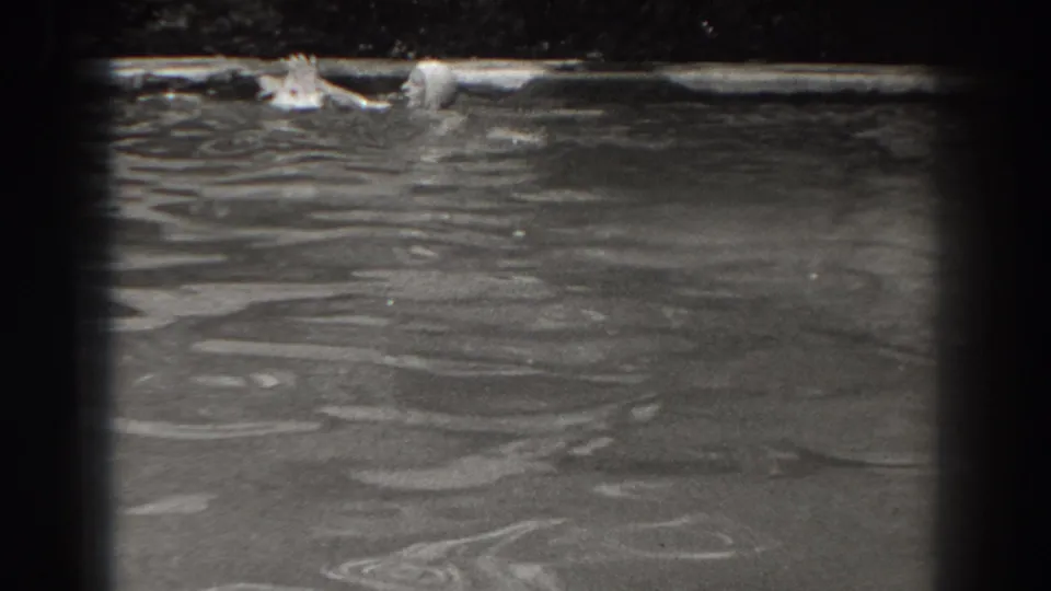 A woman in a swim cap appears at the surface of a New Jersey pond or lake in late-1930s home-movie footage.