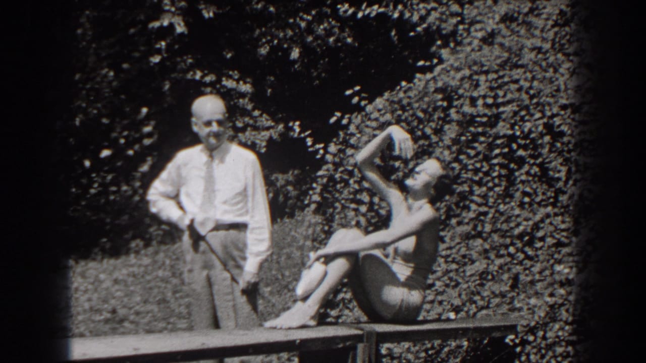 1938 New Jersey garden frame with a man holding a golf club and a seated woman adjusting her hair or posing.