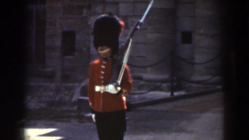 A closer 1938 Quebec view shows the ceremonial guard's red tunic, tall black hat, rifle, and stone backdrop.