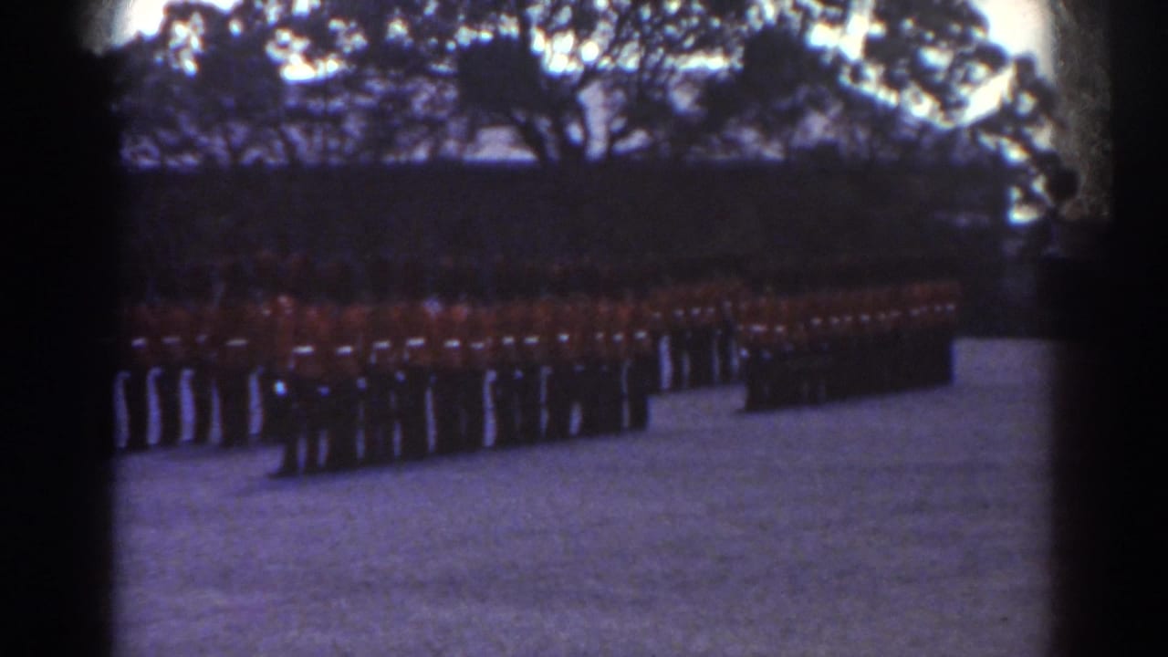 Uniformed guards in red tunics and dark hats stand in multiple rows during a ceremonial formation in Quebec.