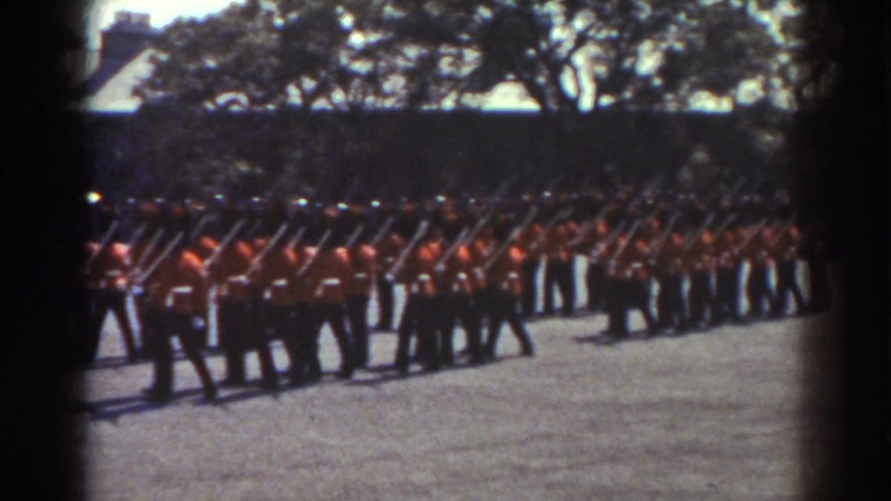 Uniformed guards march in formation with rifles over their shoulders.