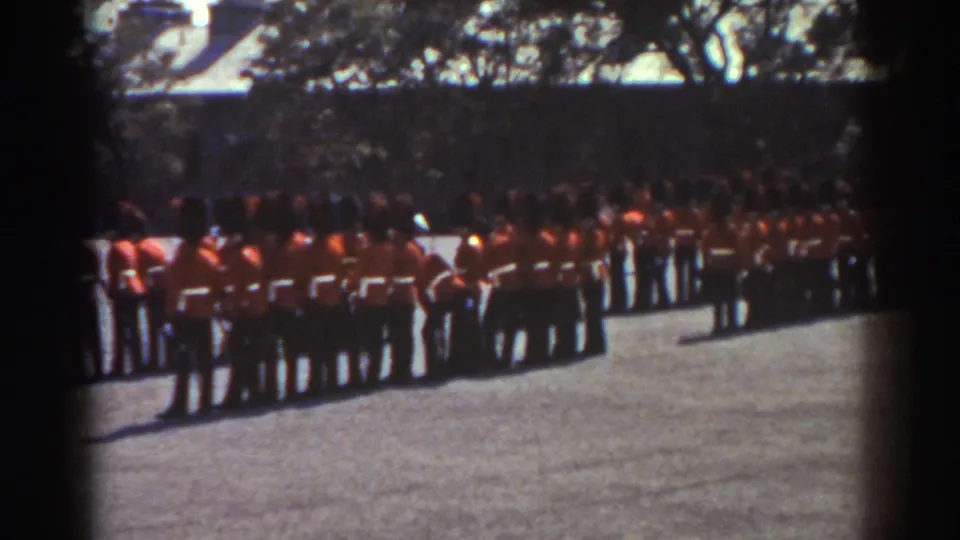 The final frame shows guards in red coats and dark hats lined across the courtyard, with trees and rooflines behind them in Quebec, 1938.