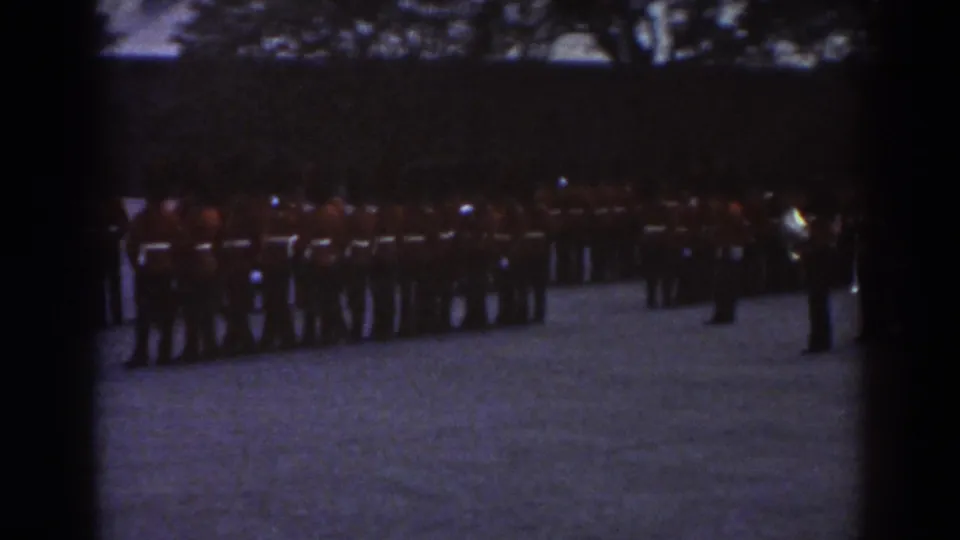 Quebec 1938 frame showing the military formation on the courtyard, with a separate uniformed figure at the right edge.