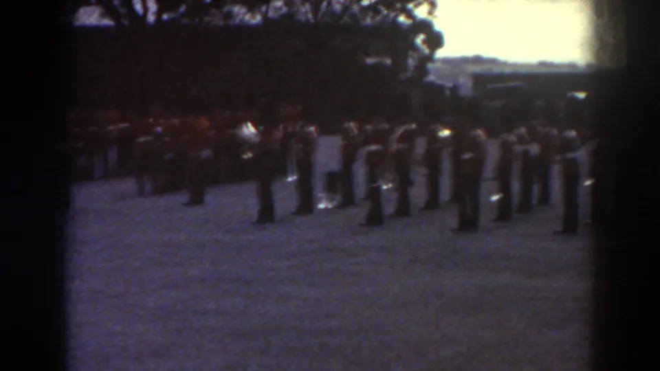 1938 Quebec footage shows uniformed adults grouped in ranks, possibly a ceremonial band or drill unit, on an open field.