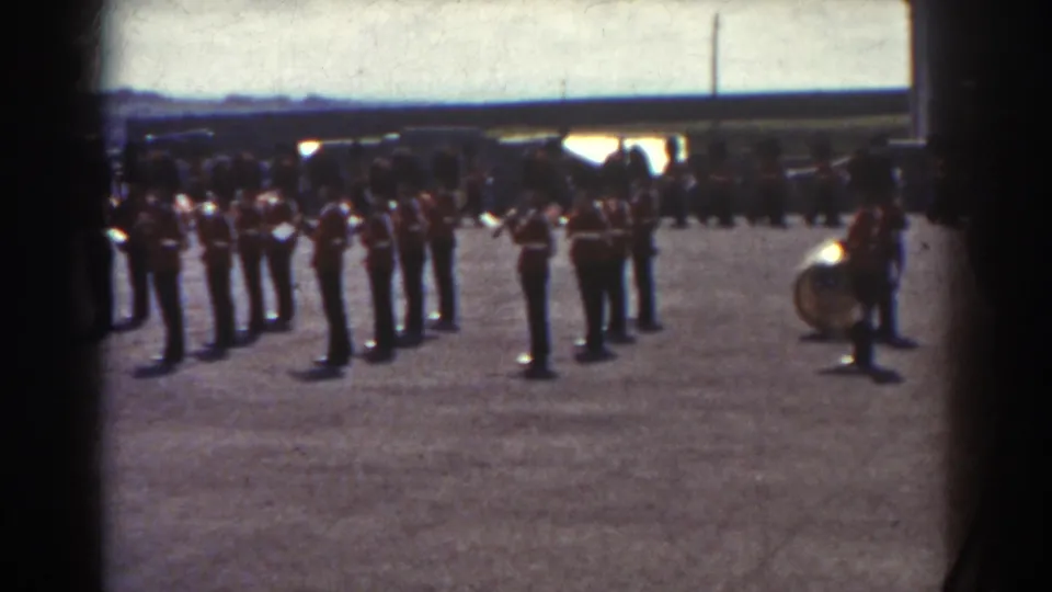 1938 Quebec scene of ceremonial guards and band members standing on a courtyard with spectators behind them.