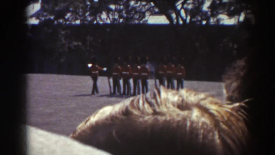 The ceremony continues as red-uniformed men stand in a line, viewed from behind a crowd in Quebec, 1938.