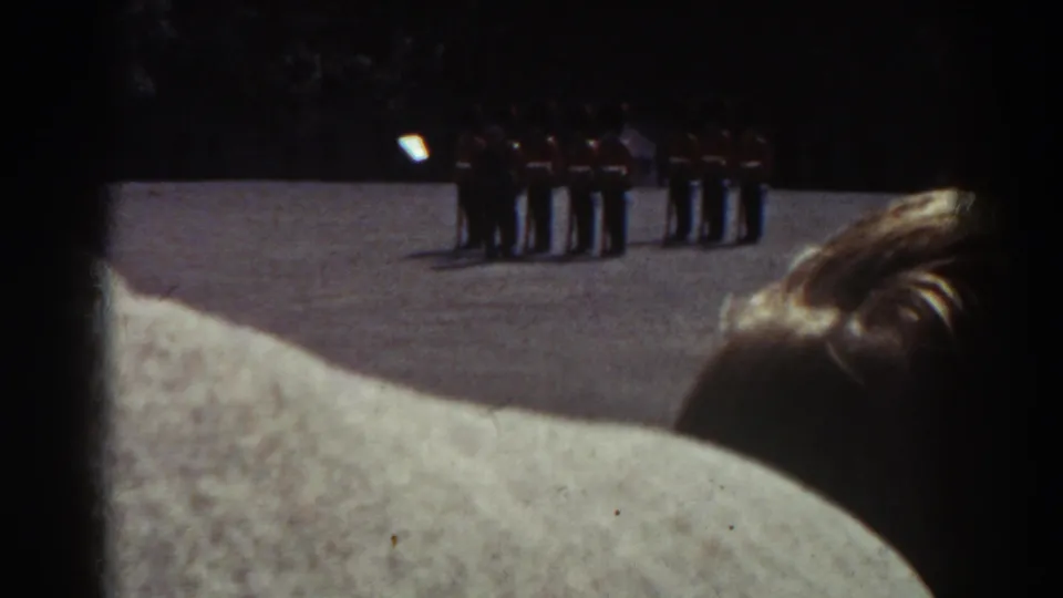 Quebec 1938 8mm footage frame showing uniformed soldiers at attention, seen past civilians in the foreground.