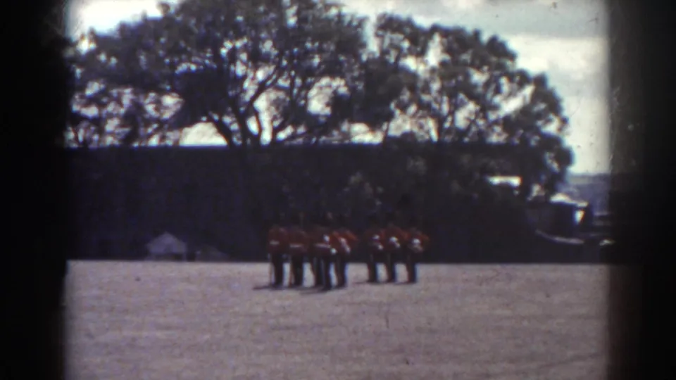 1938 Quebec frame showing the band in red uniforms arranged in two distant rows on an outdoor field.